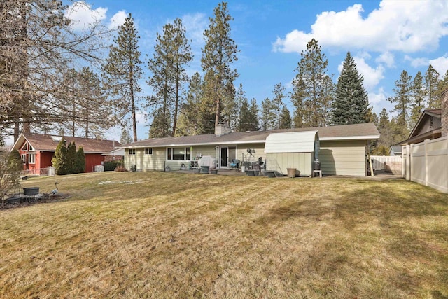 rear view of property with a storage shed and a lawn