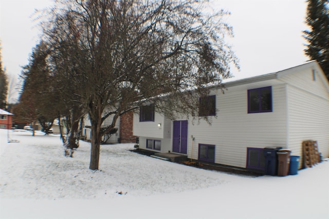 view of snow covered back of property