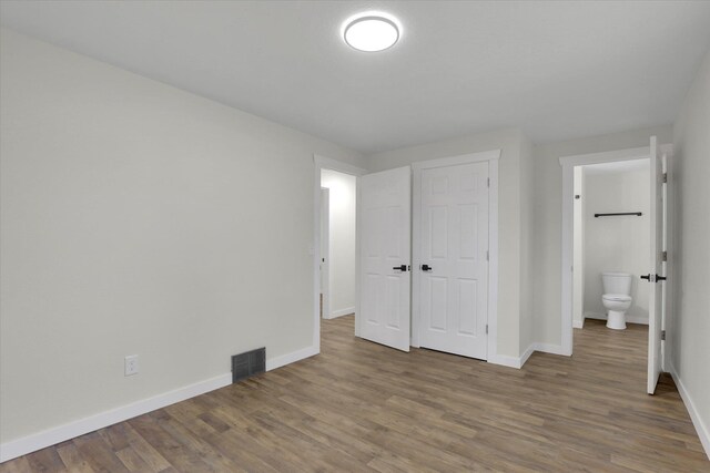 bathroom with tiled shower / bath and wood-type flooring