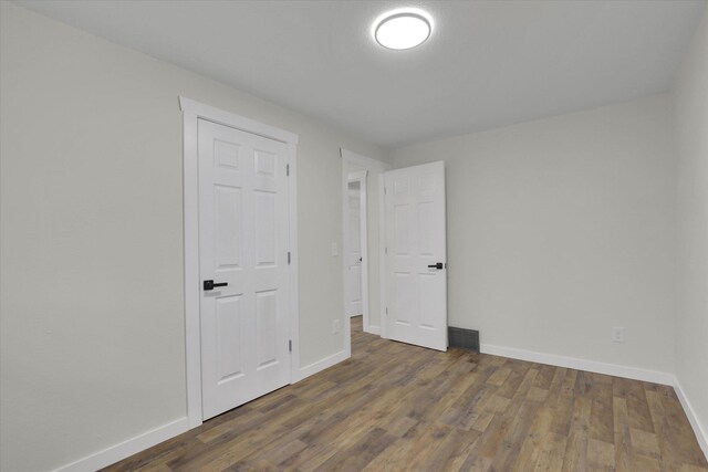 empty room with dark hardwood / wood-style flooring