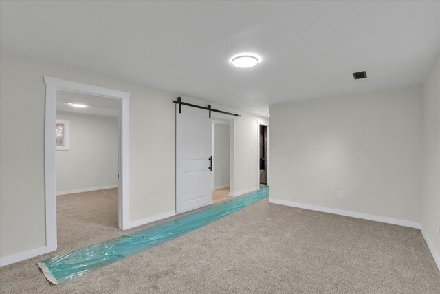 interior space with dark colored carpet and a barn door