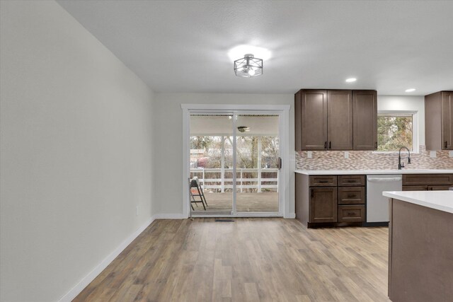 kitchen featuring dark hardwood / wood-style flooring, decorative backsplash, hanging light fixtures, a center island, and dark brown cabinets