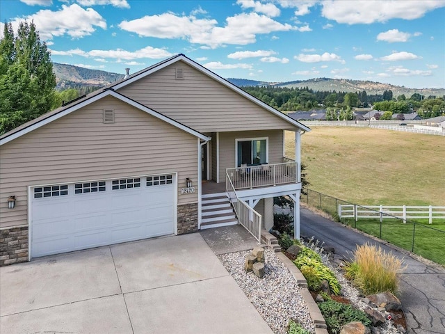 view of front of house featuring a garage, a mountain view, covered porch, and a front yard