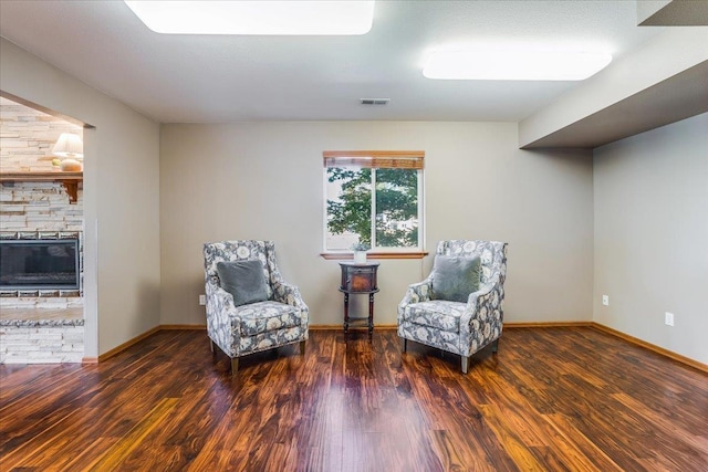 sitting room with a fireplace and dark hardwood / wood-style flooring