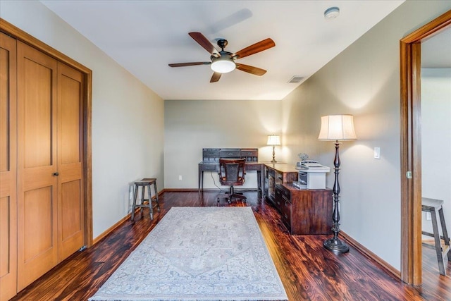 home office with dark wood-type flooring and ceiling fan