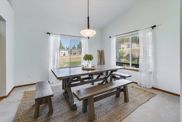 dining space with lofted ceiling and carpet flooring