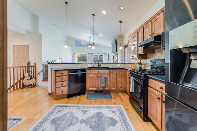 kitchen featuring sink, pendant lighting, kitchen peninsula, and black appliances