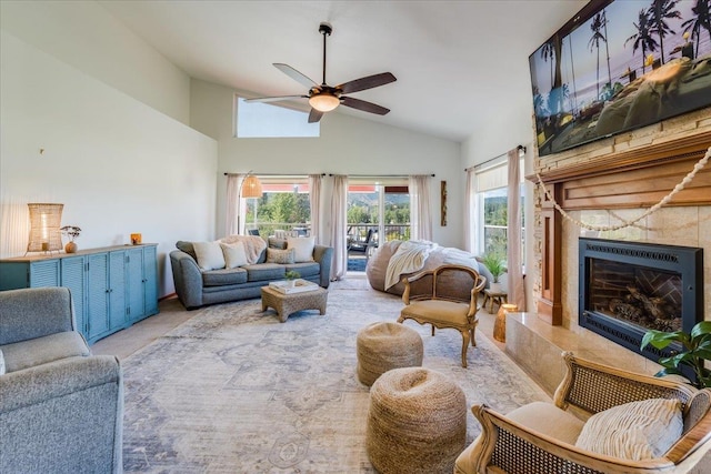 carpeted living room featuring a high end fireplace, high vaulted ceiling, and ceiling fan