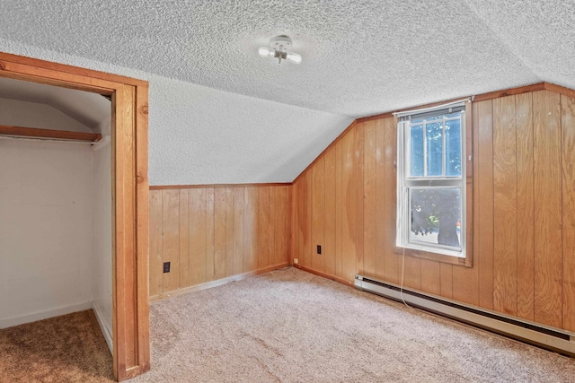 bonus room featuring a baseboard radiator, lofted ceiling, light carpet, and a textured ceiling