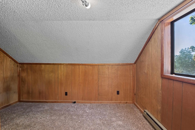 additional living space featuring a baseboard radiator, lofted ceiling, light colored carpet, and wooden walls