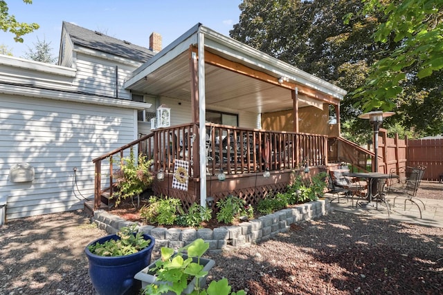 back of house featuring a deck and a patio