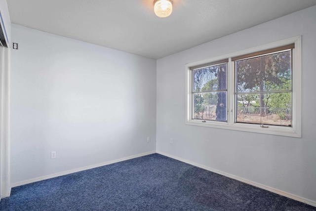 spare room with dark colored carpet