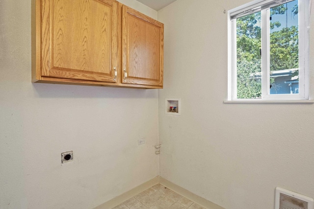 clothes washing area featuring washer hookup, electric dryer hookup, plenty of natural light, and cabinets