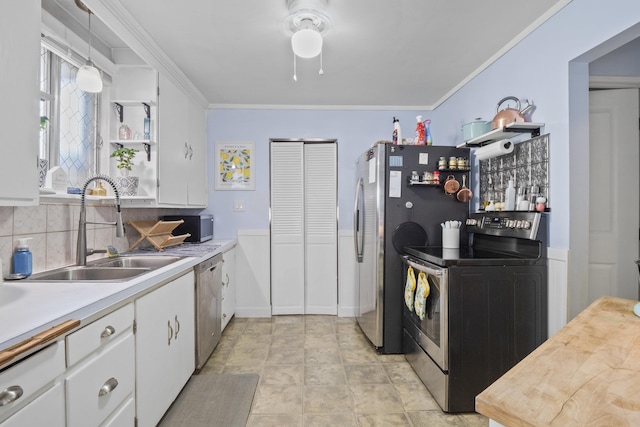 kitchen featuring sink, crown molding, hanging light fixtures, stainless steel appliances, and white cabinets