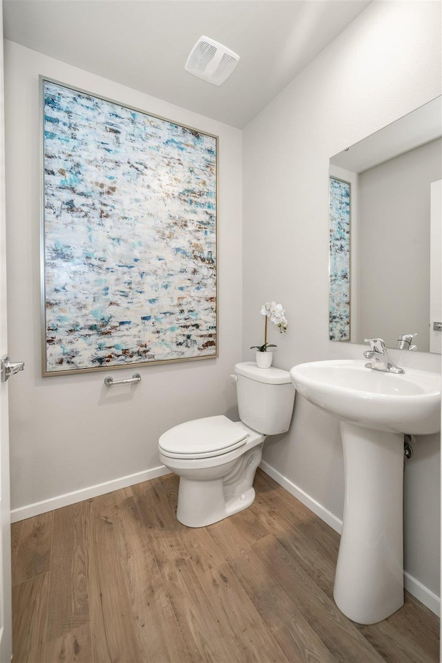 bathroom with wood-type flooring and toilet