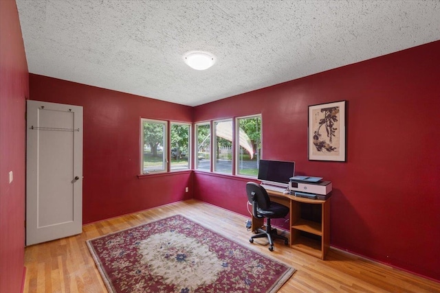 home office with wood-type flooring and a textured ceiling