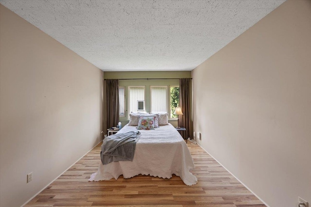 bedroom with a textured ceiling and light hardwood / wood-style flooring