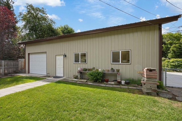 rear view of house with a garage and a lawn