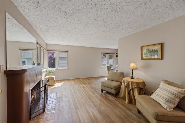 sitting room with a textured ceiling, light hardwood / wood-style floors, and a healthy amount of sunlight