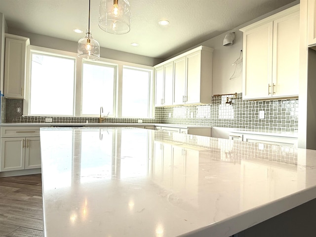 kitchen with light stone countertops, recessed lighting, decorative light fixtures, and decorative backsplash