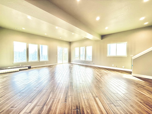 unfurnished living room featuring baseboards, recessed lighting, and wood finished floors