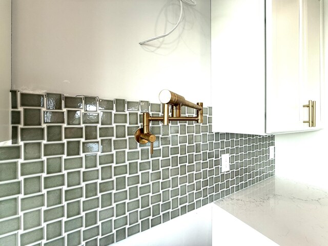 interior details with white cabinetry and decorative backsplash