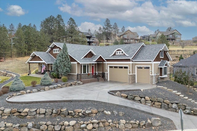 craftsman-style home with an attached garage, stone siding, and concrete driveway