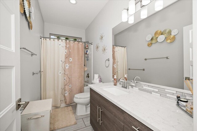 full bathroom featuring vanity, shower / tub combo, and toilet