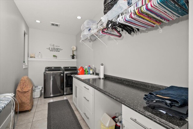 laundry area with sink, light tile patterned floors, cabinets, and washing machine and clothes dryer