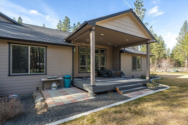 rear view of property with a patio, a deck, and a lawn