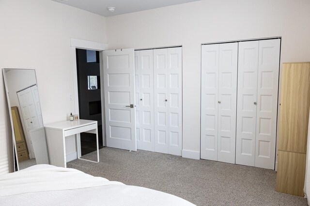 carpeted bedroom featuring two closets