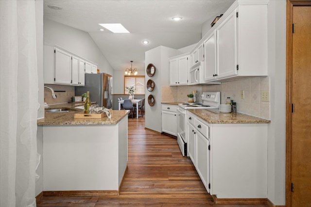 kitchen featuring sink, white cabinetry, light stone counters, kitchen peninsula, and white appliances