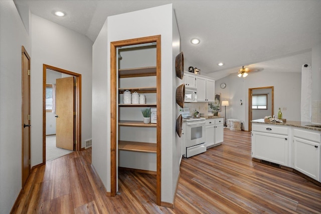 kitchen featuring white cabinetry, white appliances, lofted ceiling, and hardwood / wood-style flooring