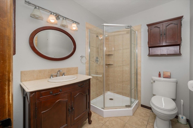 bathroom featuring tile patterned floors, vanity, toilet, and a shower with shower door