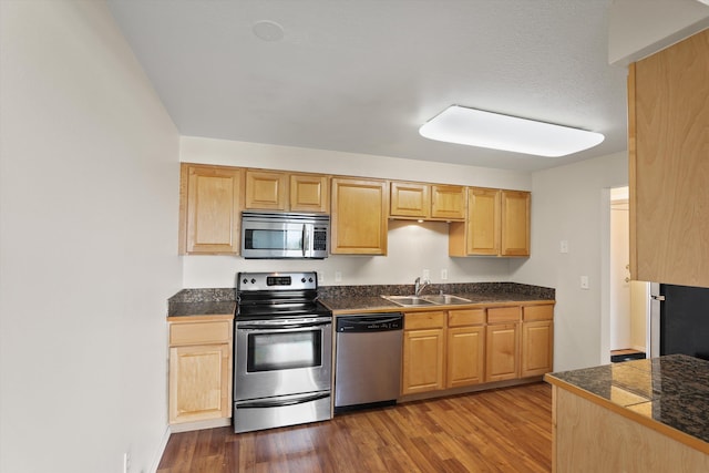 kitchen with appliances with stainless steel finishes, sink, light brown cabinets, and dark hardwood / wood-style floors