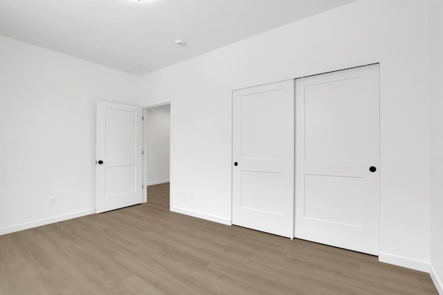 unfurnished bedroom with hardwood / wood-style floors and a closet