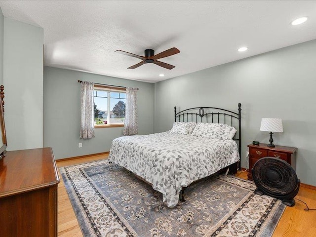 bedroom featuring hardwood / wood-style flooring, a textured ceiling, and ceiling fan