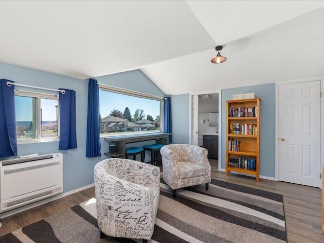 sitting room with heating unit, vaulted ceiling, and dark hardwood / wood-style floors