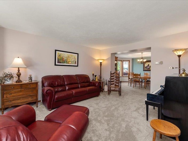 carpeted living room featuring a textured ceiling and a chandelier