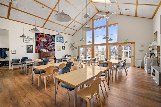 dining space featuring hardwood / wood-style floors and high vaulted ceiling