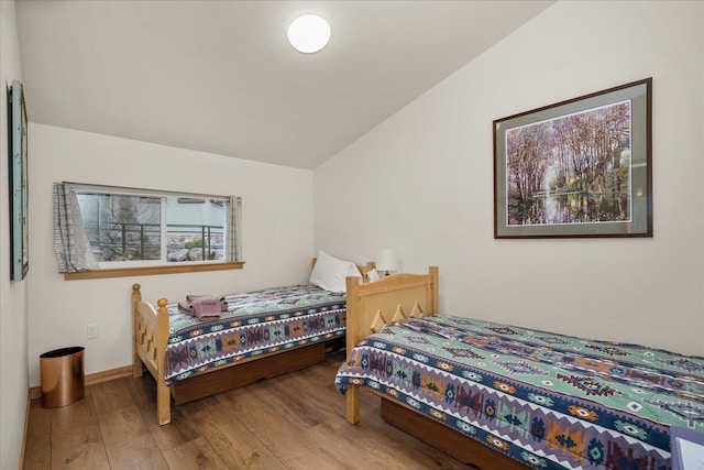 bedroom with hardwood / wood-style flooring and vaulted ceiling