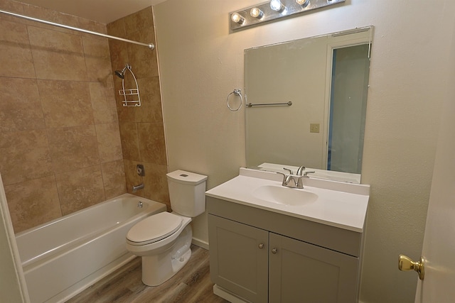 full bathroom with hardwood / wood-style flooring, vanity, toilet, and tiled shower / bath combo