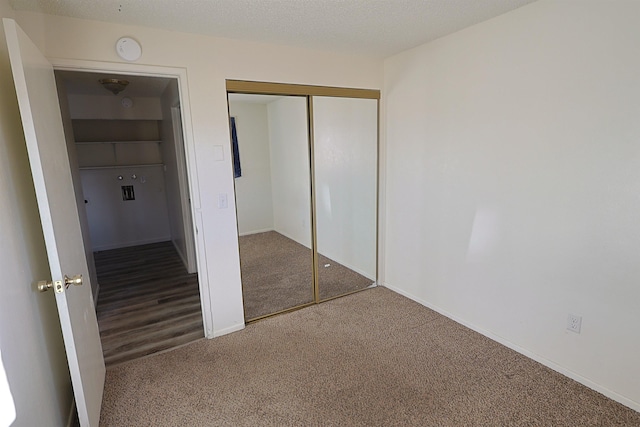 unfurnished bedroom with carpet floors, a closet, and a textured ceiling