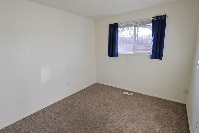 carpeted spare room featuring a textured ceiling