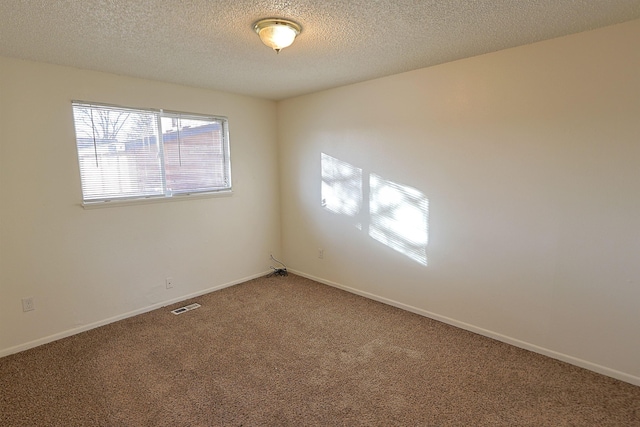 spare room featuring carpet flooring and a textured ceiling