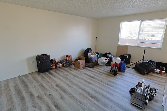 misc room with a textured ceiling and light wood-type flooring