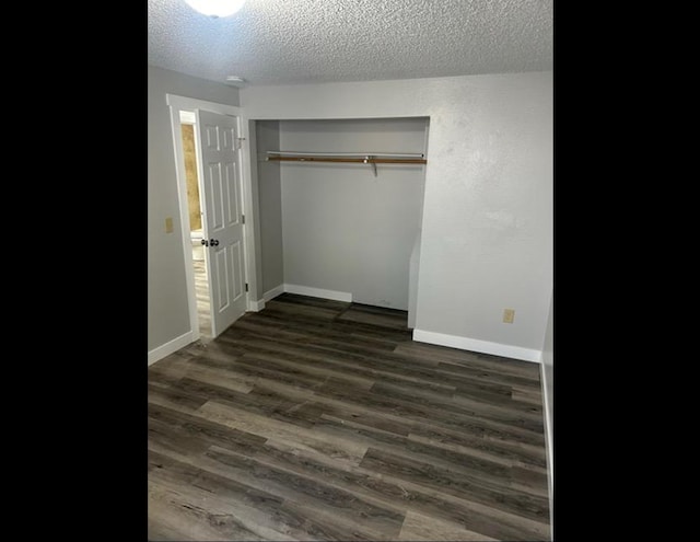 unfurnished bedroom with dark wood-type flooring, a closet, and a textured ceiling