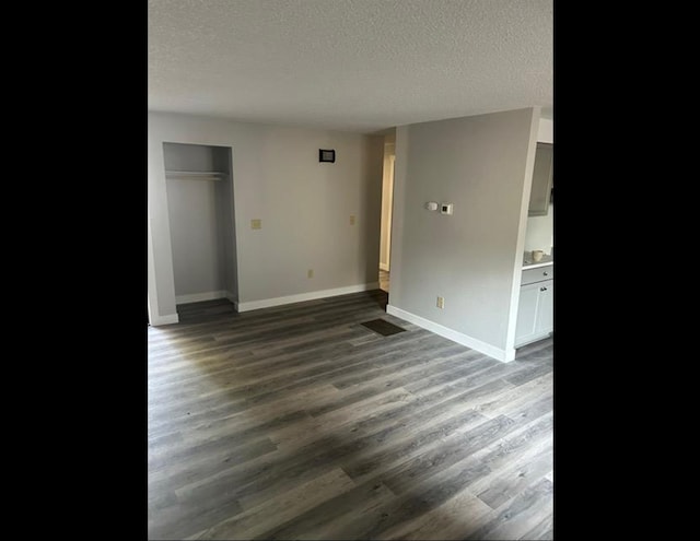 unfurnished bedroom with a closet, dark hardwood / wood-style floors, and a textured ceiling