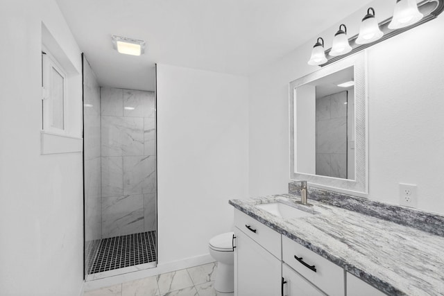 bathroom featuring vanity, toilet, and a tile shower