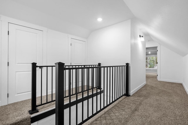 hall featuring lofted ceiling and carpet flooring